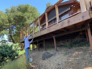 Construction worker building a wood deck structure on a residential property