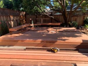 Wood deck construction site with framing tools and structural base in progress